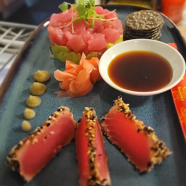 Tuna tartare with avocado, seared tuna, pickled ginger, wasabi, soy sauce, and crackers.